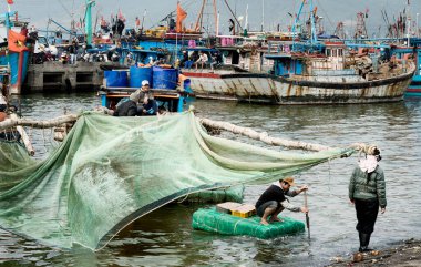 Balıkçı sepetleri karides ile shoreside için getiriyor. 26 Aralık 2013 - Da Nang, Vietnam