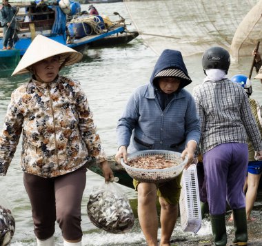 Bir balık taze yakalamak ile plastik torbalar ve karides sepet taşıyan kadınlar. 26 Aralık 2013 - Da Nang, Vietnam