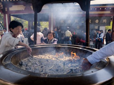 Japon kadın ışıklar sopa büyük bronz tütsü brülör veya koro Senso-ji Tapınağı'nda tütsü. 15 Nisan 2014 - Asakusa, Tokyo, Japonya