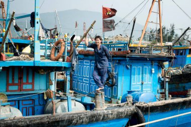 Balıkçı teknesinde ayakta gülümseyerek. 26 Aralık 2013 - Da Nang, Vietnam
