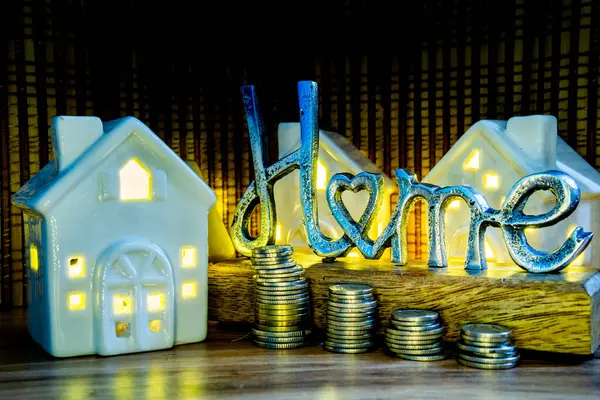 home price increase concept illustration metal home sign with coins and ceramic houses with light buying house from an agent