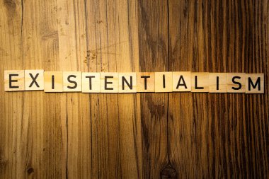 Varoluşçuluk kavramı kelime ahşap harflerle siyah ahşap arka plan