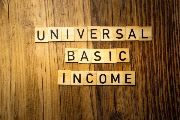 stock image Universal Basic Income concept word in wooden letters on dark wood background