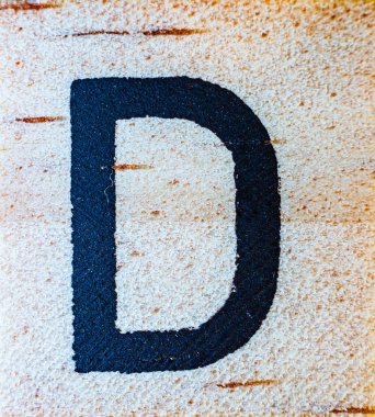 Balsa tahtası makrosu üzerine D harfi kazınmış lazer. Doku detaylarını kapat.