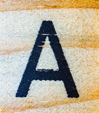 Balsa ahşap makrosuna oyulmuş A harfi. Doku detaylarını kapat.