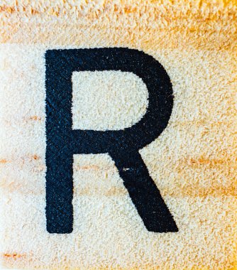 Balsa tahtası makrosu üzerine R harfi lazer oyması. Doku detaylarını kapat.