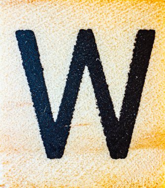 Balsa ahşap makrosuna oyulmuş W harfi lazer. Doku detaylarını kapat.