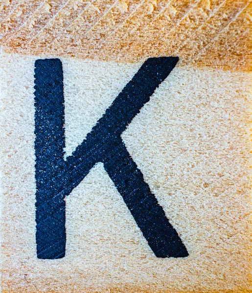 刻有字母K激光的巴尔萨木宏观贴合纹理细节 — 图库照片