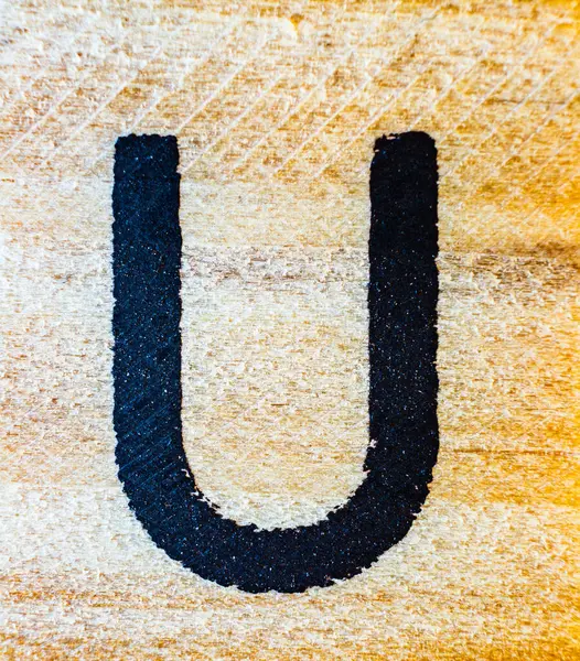 刻有字母U的激光雕刻在巴尔萨木料上的宏观贴合纹理细节 — 图库照片