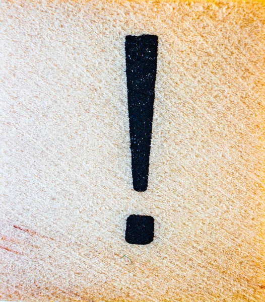 Exclamation mark symbol laser engraved on balsa wood macro close up texture detail