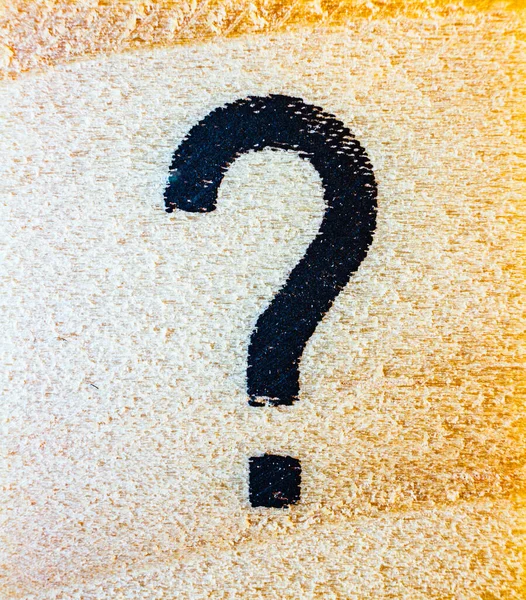 Question mark symbol laser engraved on balsa wood macro close up texture detail