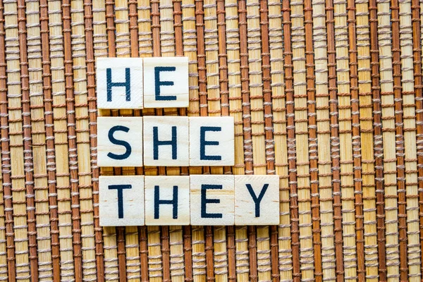 stock image Pronouns He She They concept word in wooden letters on straw mat background