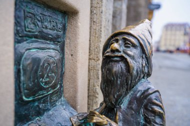 Wrocaw, Polonya - 08 Aralık 2023: Iconic Wrocaw Cücelerinden birinin adı Bankus. Cüceler, insanların bulması için tüm şehre yayılmış bir turistik cazibedir.