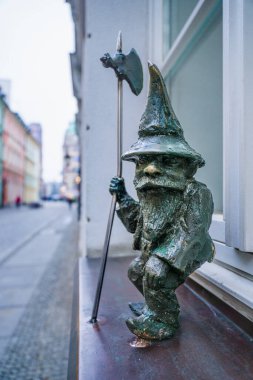 Wrocaw, Polonya - 08 Aralık 2023: Camda oturan Stranik adında bir cüce. Iconic Wrocaw Cüceleri insanların bulması için tüm şehre yayılmış bir turistik cazibedir.