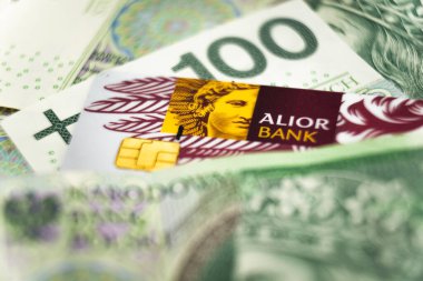 Wabrzych, Polonya - 11.12.2023: Polonya zloti banknotları arasında bir kredi kartı üzerindeki Alior banka logosu. Alior Bank 2008 yılında Polonya 'nın en büyük bankalarından biri.