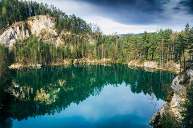 Ağaçlar ve uçurumlarla çevrili göl