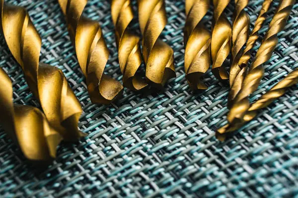 Bir bez yüzey üzerinde düzgünce düzenlenmiş matkap ve vida bitleri koleksiyonu yakın çekim görüntüsü