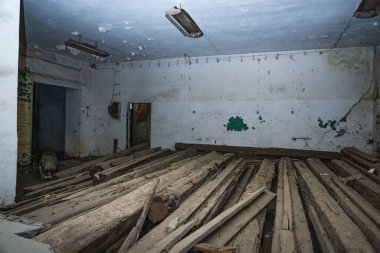 Eski harabe, tozla kaplı terk edilmiş binadaki kırık ahşap odunlarla dolu.