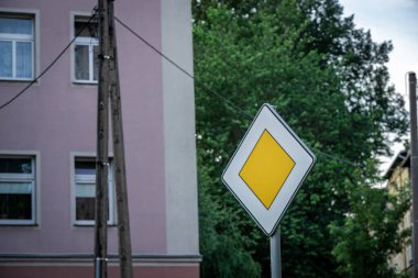 Güneşli bir günde Binanın Önündeki Öncelikli Yol İşareti