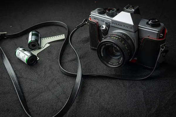 stock image Vintage Praktica mtl 50 German Camera With Film Rolls on a Dark Surface