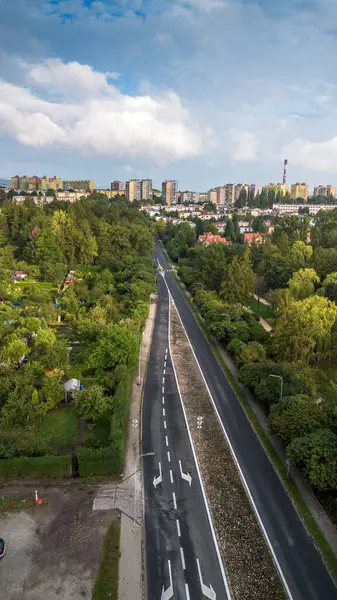 stock image Scenic Aerial View of a Quiet Road Surrounded by Lush Greenery and Urban Landscape