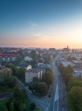 Gün batımında sakin bir kasabanın hava manzarası. Virajlı yollar ve konut binaları.