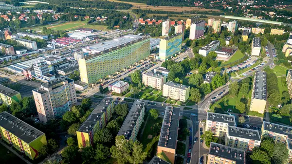 Akşamüstü aydınlığında yeşil alanları ve kentsel binaları olan yerleşim yerlerinin hava manzarası.