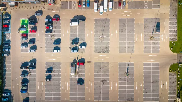 Stock image Aerial view of an empty parking lot with scattered vehicles on a sunny day