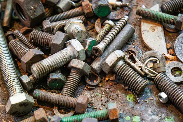 stock image Metal working workshop with assorted screws, bolts, and nuts on a workbench covered in grime and tool remnants