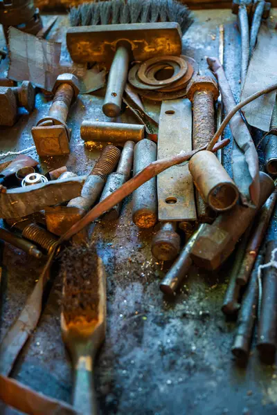 Bir metal atölyesinde paslanmış metal aletlerin ve bağlayıcıların koleksiyonu