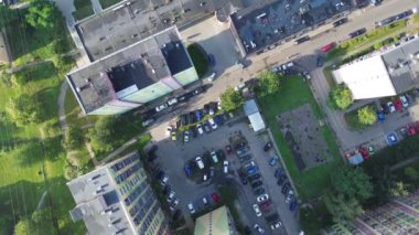 Yoğun bir otoparkın havadan görüntüsü ve öğleden sonra kent ortamında binalar