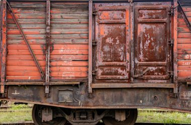 Eski paslı bir buharlı trenin kırmızı arka planının detaylı görüntüsü.