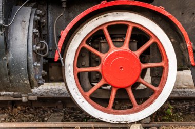 Paslı buharlı tren tekerleği resimli bir ortamda eski bir lokomotifin karmaşık detaylarını gösteriyor