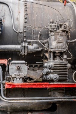 Eski paslı bir buhar treni motoru, karmaşık makineler ve yıpranmış metal parçaları.