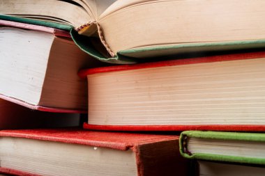 Öğrenim ve öğrenim amacıyla düzenli olarak bir yüzeye dizilmiş renkli eğitim kitapları yığını
