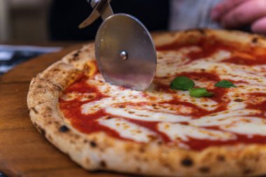 Konforlu bir restoranda servis edilen taze jambonlu pizzanın tadını çıkarıyorum.