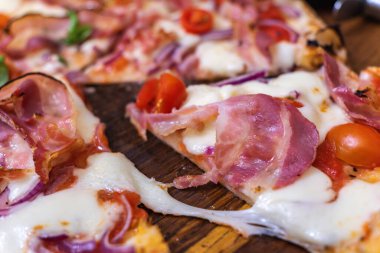 Fırından taze otlar ve domateslerle servis edilen lezzetli pizza prosciutto.