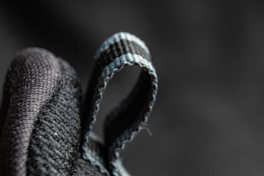 Ayrıntılı bir yakın plan, ayakkabı kumaşının eşsiz dokusunu ve tasarımını yakalar, düğümlenmiş etiketi vurgular