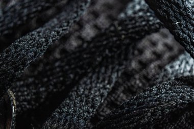 Yumuşak eğimli bir zeminde, karmaşık siyah ayakkabı bağcıklarının yakın çekimi