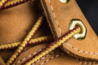 Tarafsız bir arkaplanda karmaşık bağcıklı kahverengi deri bir ayakkabının yakın çekimi.