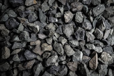 İnşaat veya peyzaj projeleri için düz bir yüzey üzerinde çeşitli boyutlarda siyah çakıl görüntüsü