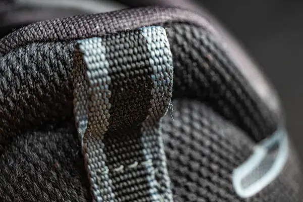 Yumuşak odaklı arka planda modern bir ayakkabıya desenli kumaş ve dikişlerin yakın plan detayları