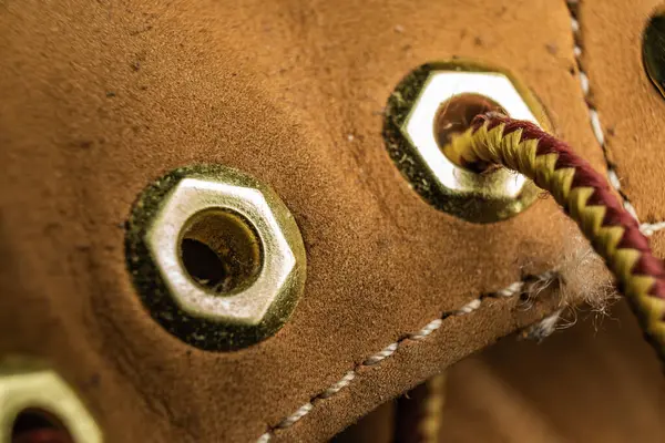 Göz dirseğini ve dantelini sıcak tonda vurgulayan bir ayakkabı detayının yakın çekimi