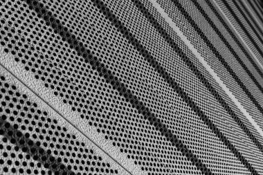 Modern mimari ortamda dairesel deliklerle desenli metal yüzey