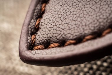 Kalıplı kahverengi kumaş sergilenen, karmaşık dikiş detaylarının yakın görüntüsü