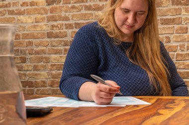 Şaşkın Kadın kapalı bir ortamda 1040 ABD gelir vergisi formunu tamamlamaya odaklandı