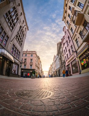 Ziyaretçiler Torun 'daki szeroka caddesinde dolaşırken, güneş tarihi binaların altına batarken canlı atmosferi kucaklıyorlar..