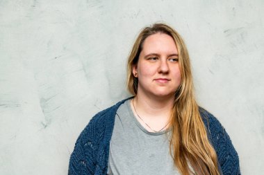 Kendine güvenen bir anne, güzelliğini göstererek o anın sıcaklığını ve sağlığını somutlaştıran basit, modern bir arka plana gülümsüyor..