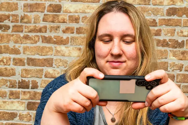 Samimi bir ortamda, güzel bir anne akıllı telefonuna odaklanır, kendi rahatlığı içinde huzurlu bir bağlantı anını kucaklar..