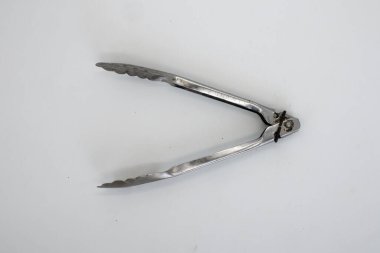 Maşa ya da tava beyazın üzerinde paslanmaz izole edilmiş.